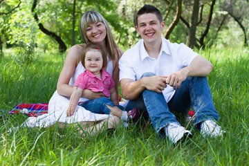 Fototapeta premium Young family of three on a picnic