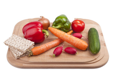 studio-shot of a wooden board with vegetables and crispbread