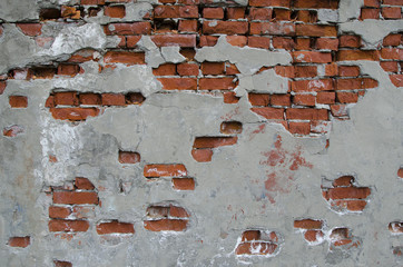 Partially plastered wall with red bricks