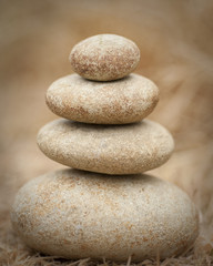 Fototapeta na wymiar pile of rocks balanced against hay background