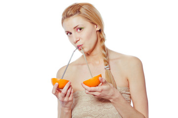 woman drinking juice direct from an orange fruit using a straw