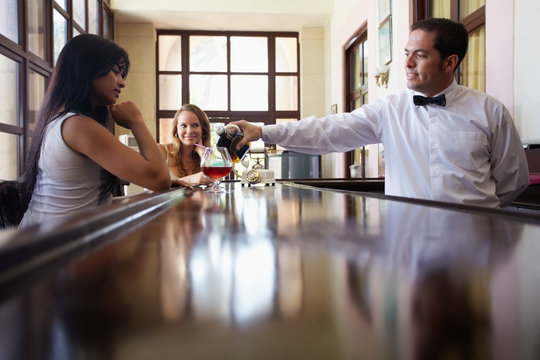 women drinking cocktail in pub