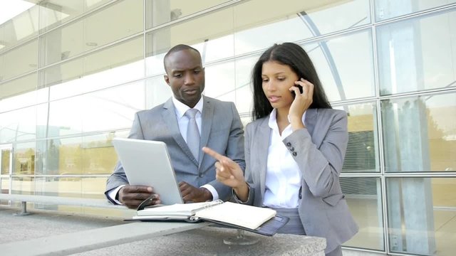 Business team working on electronic tablet outside
