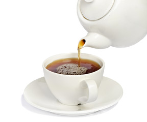 Tea being poured into  tea cup isolated on a white background