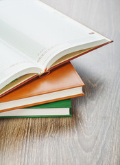 three notebooks on wooden background