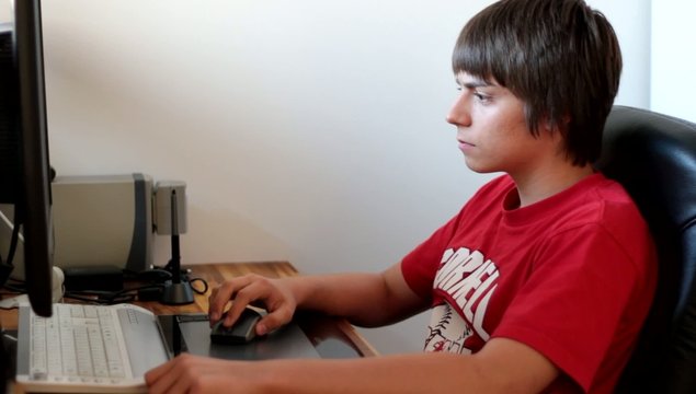 adolescent travaillant devant l'ordianteur