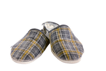 Old worn house slippers on a white background.