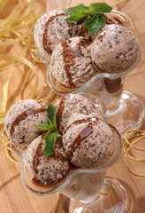 Peppermint ice cream with chocolate sauce and mint in a vertical