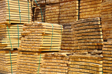 Pile of wooden rails in open warehouse.