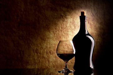 Cognac Glass and Bottle on a old stone background