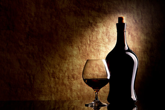 Cognac Glass and Bottle on a old stone background