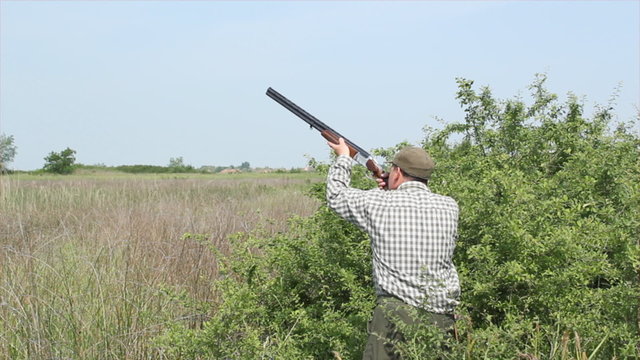 hunter loading shotgun and shooting