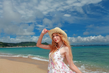 Fototapeta na wymiar 久高島の波打ち際で寛ぐ笑顔の女性