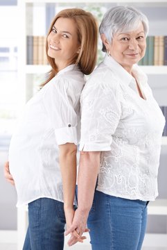 Senior mother and pregnant daughter smiling