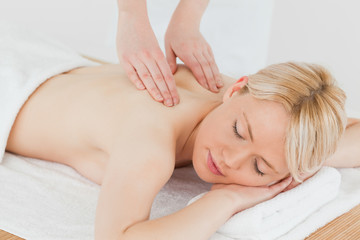 Fototapeta na wymiar Closeup of young gorgeous blonde woman receiving a back massage