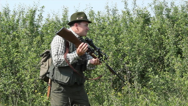 hunter with binoculars and rifle