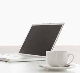 Fototapeta premium Modern laptop and cup of tea on a table