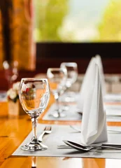 Foto op Canvas Glasses and plates on table in restaurant © Nikolai Sorokin