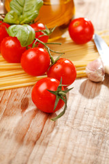 pasta, olive oil and tomatoes on the wood background