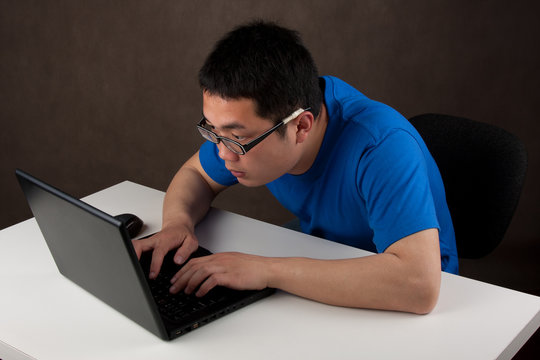 young asian man working on his laptop computer