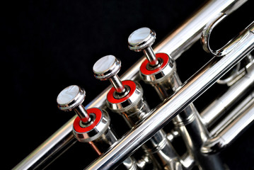 Silver Trumpet valves close up on a black background