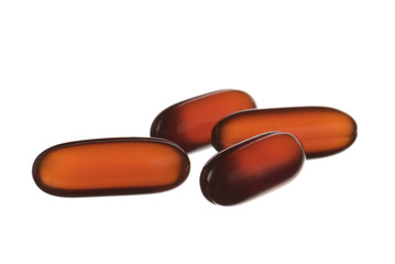 close up orange capsules isolated on white
