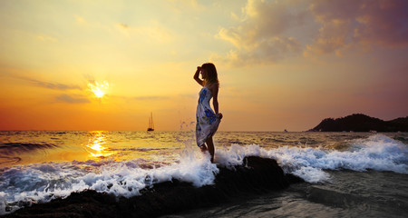 Young woman standing on rock in sea and looking to somewhere © Dudarev Mikhail