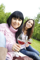 Mother and daughter drinking wine outdoors