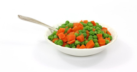Peas and carrots in white dish with spoon