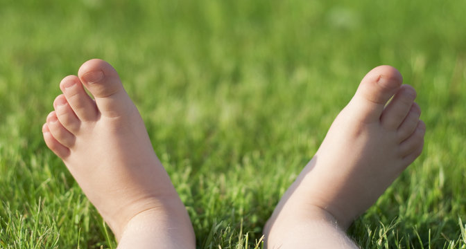 Child's barefeet on green grass