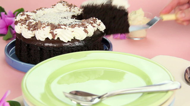 A slice of chocolate mud cake being served on to a plate