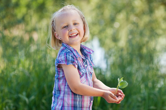glückliches kind hält pflanze in händen