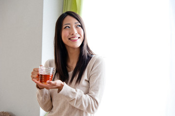 beautiful asian woman drinking a glass of tea