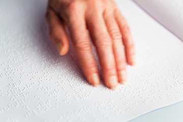 Braille and finger. Book in Braille