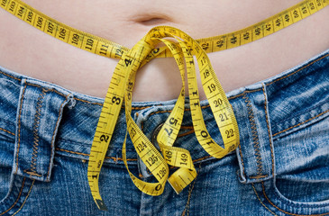 diet concept. Jeans and yellow measuring tape.