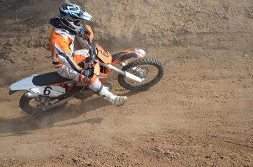 Motocross rider on the motorcycle accelerates from turning