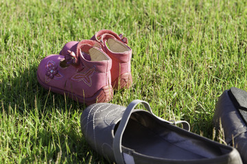 Детские и женские туфли на зеленой траве