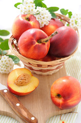 Fresh, ripe nectarines in a basket on board