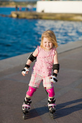 Young pretty girl on rollerskates in the park