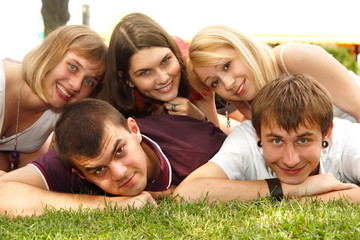 students happy friends group lying on grass