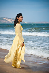 Young Asian Woman in yellow ao dai on the Beach