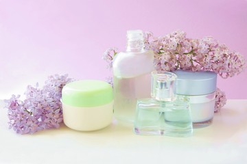 Fototapeta na wymiar cosmetics and fragrant lilac flowers