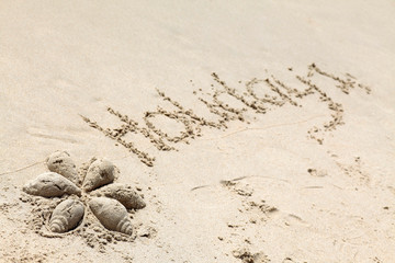Holiday text on sand