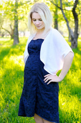 Beautiful young pregnant woman in park