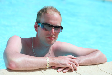 Portrait of a young handsome man in the pool