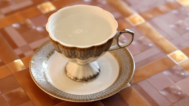 brewing black tea in white cup on the table