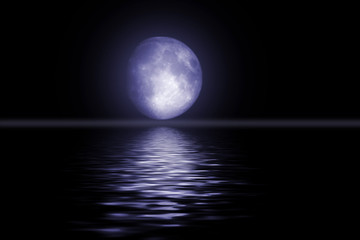 The full moon in the night sky reflected in water