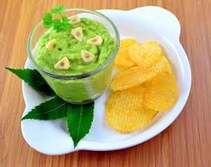 Garlic avocado guacamole dip in glass with crackers