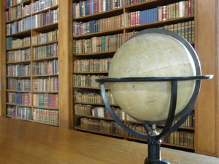 Rows of books on library shelves and a globe