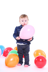 Fototapeta na wymiar little girl plays with color balloons